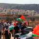 Palestinian and foreign demonstrators raise the Palestinian flag in Bilin opposite the settlements bloc of Modiin Illit in the occupied West Bank on October 4, 2019, during a protest against settlement construction and in solidarity with Palestinian prisoners held in Israeli jails.